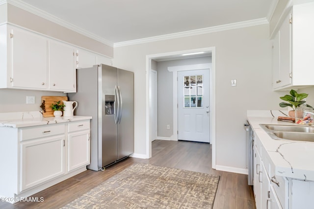 1010 Domingue St, Breaux Bridge, LA 70517 - kitchen featuring stainless steel fridge with ice dispenser, wood finished floors, ornamental molding, and white cabinetry