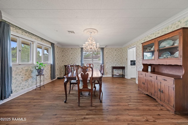 630 W Peach Ave, Eunice, LA 70535 - dining space featuring wallpapered walls, dark wood finished floors, a chandelier, ornamental molding, and baseboards