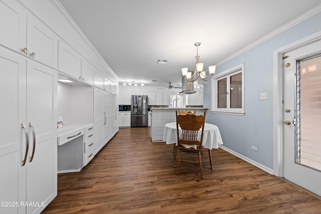 630 W Peach Ave, Eunice, LA 70535 - dining room featuring a chandelier, dark wood-type flooring, crown molding, ceiling fan, and baseboards