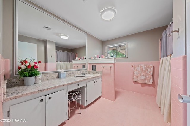 630 W Peach Ave, Eunice, LA 70535 - bathroom with tile walls, vanity, wainscoting, and a shower with shower curtain