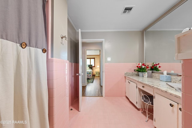 630 W Peach Ave, Eunice, LA 70535 - full bath with tile walls, wainscoting, vanity, ornamental molding, and tile patterned floors