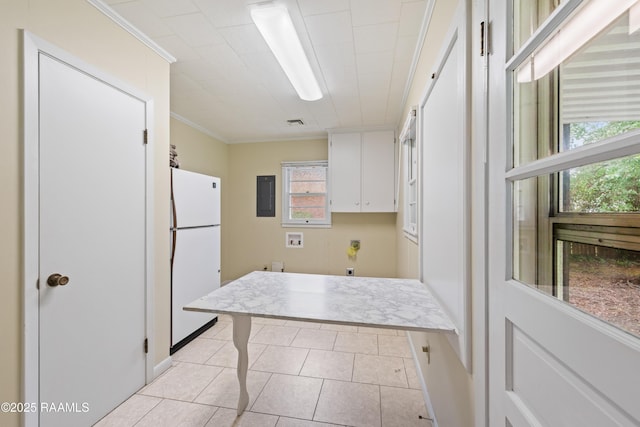 407 N Hebert Ave, Kaplan, LA 70548 - kitchen with freestanding refrigerator, white cabinets, electric panel, light tile patterned floors, and ornamental molding