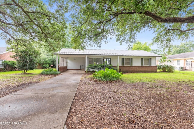 407 N Hebert Ave, Kaplan, LA 70548 - ranch-style house with brick siding, a front lawn, concrete driveway, an attached carport, and metal roof