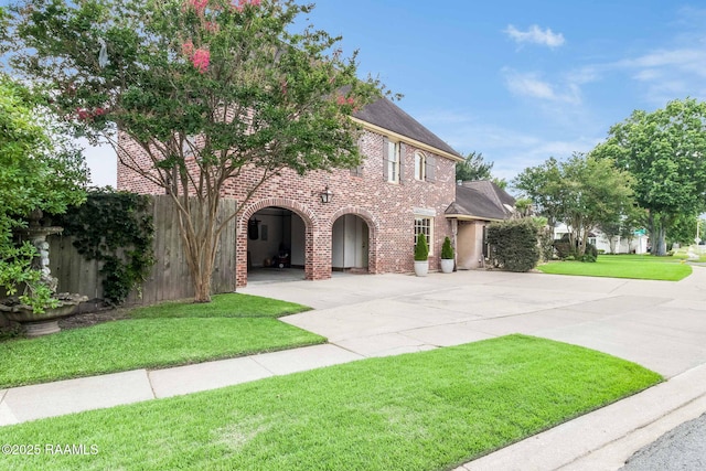 101 Hanover Sq, Lafayette, LA 70508 - view of front of home featuring brick siding, a front yard, curved driveway, and a shingled roof