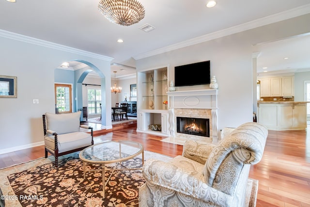 101 Hanover Sq, Lafayette, LA 70508 - living area featuring a chandelier, arched walkways, light wood-style floors, ornamental molding, and recessed lighting