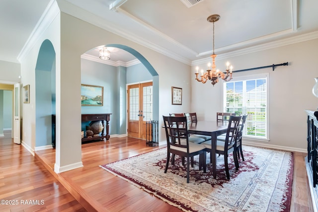 101 Hanover Sq, Lafayette, LA 70508 - dining room featuring arched walkways, plenty of natural light, french doors, a chandelier, and crown molding