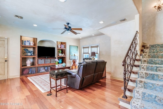 101 Hanover Sq, Lafayette, LA 70508 - living area featuring light wood finished floors, a ceiling fan, built in shelves, stairs, and recessed lighting