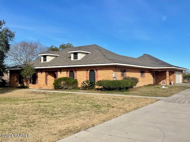 1944 Mills St, Scott, LA 70583 - view of front facade featuring a front lawn, brick siding, and a garage