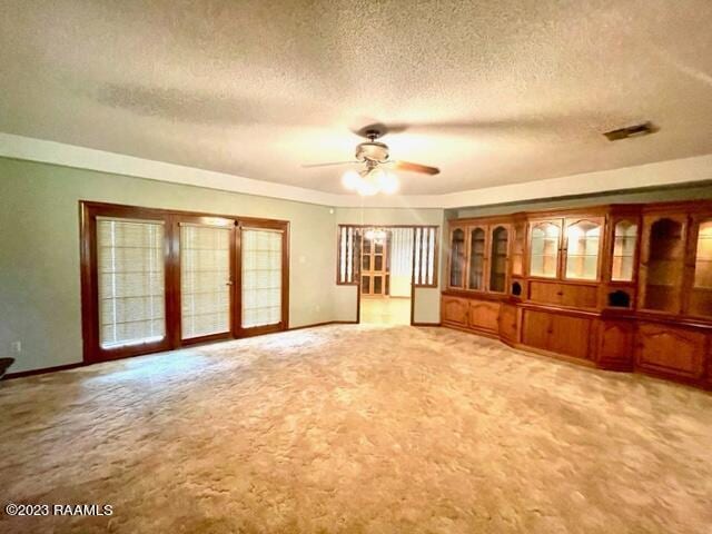 1944 Mills St, Scott, LA 70583 - unfurnished living room featuring a ceiling fan, light carpet, baseboards, and a textured ceiling