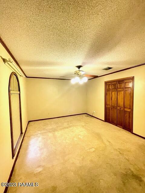 1944 Mills St, Scott, LA 70583 - unfurnished bedroom featuring crown molding, a textured ceiling, a closet, baseboards, and ceiling fan