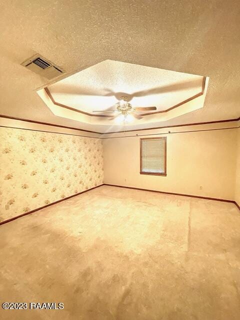 1944 Mills St, Scott, LA 70583 - carpeted empty room with a textured ceiling, ceiling fan, baseboards, wallpapered walls, and a raised ceiling