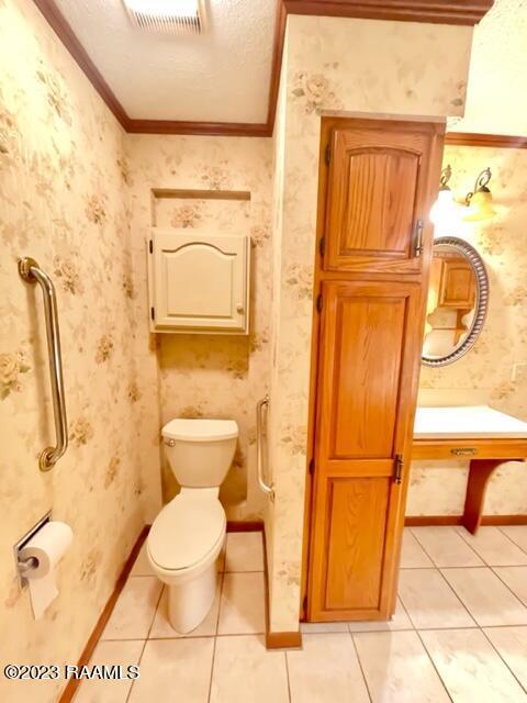 1944 Mills St, Scott, LA 70583 - half bathroom with toilet, ornamental molding, tile patterned floors, and wallpapered walls