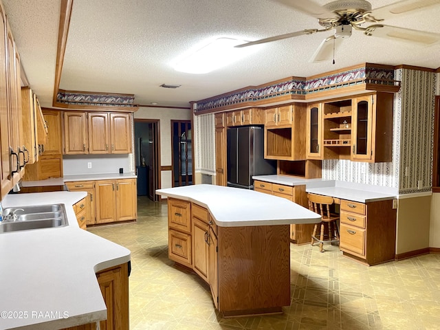 1944 Mills St, Scott, LA 70583 - kitchen featuring a sink, freestanding refrigerator, a center island, light floors, and a ceiling fan