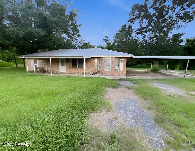 1101 Portage Rd, Arnaudville, LA 70512 - view of front of property with a front lawn, driveway, brick siding, and a carport