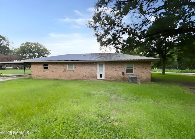 1101 Portage Rd, Arnaudville, LA 70512 - rear view of property with a yard, a metal roof, brick siding, and an attached carport
