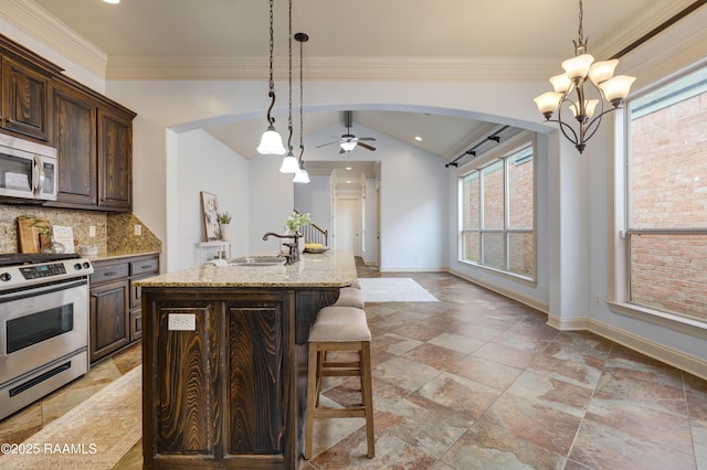 109 Flamingo Row, Lafayette, LA 70508 - kitchen with stainless steel appliances, a kitchen bar, tasteful backsplash, light stone counters, and dark brown cabinets