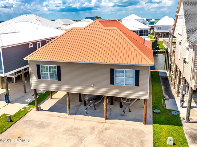 178 Flounder Ct, Dulac, LA 70353 - back of house with a residential view, metal roof, a water view, and driveway