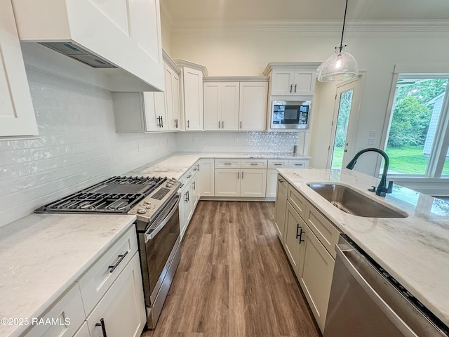 222 Timber Mill St, Lafayette, LA 70508 - kitchen featuring appliances with stainless steel finishes, a sink, ornamental molding, extractor fan, and dark wood finished floors