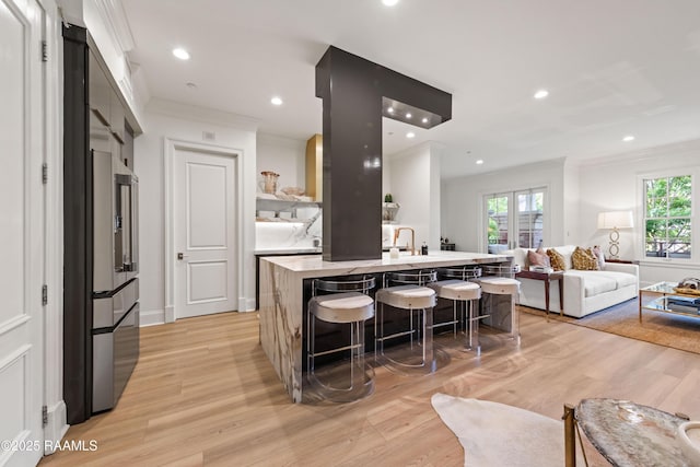 302 Richland Ave Unit 207C, Lafayette, LA 70508 - kitchen featuring ornamental molding, light wood-style floors, a kitchen breakfast bar, light countertops, and healthy amount of natural light