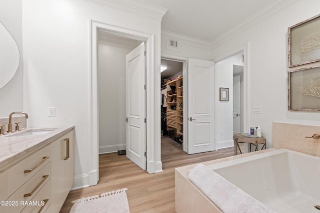 302 Richland Ave Unit 207C, Lafayette, LA 70508 - full bath featuring vanity, wood finished floors, a garden tub, ornamental molding, and a walk in closet