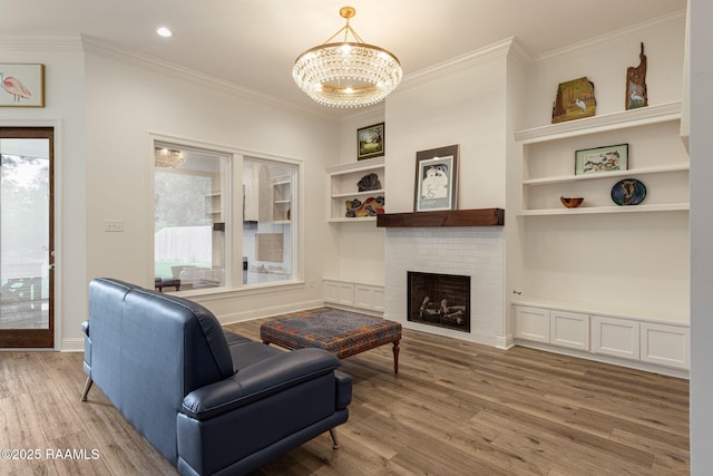 308 Manor House Ln, Lafayette, LA 70507 - living room with a chandelier, light wood finished floors, ornamental molding, built in features, and a fireplace
