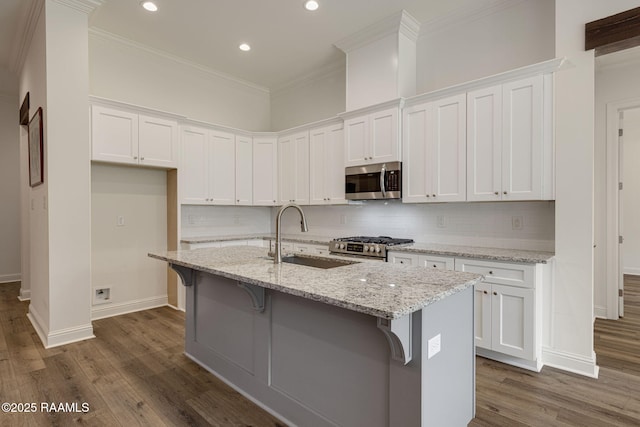 308 Manor House Ln, Lafayette, LA 70507 - kitchen featuring appliances with stainless steel finishes, a sink, ornamental molding, dark wood-type flooring, and baseboards