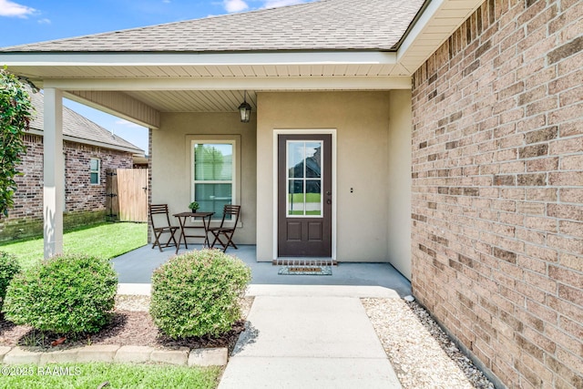 118 Barnet Ct, Lafayette, LA 70507 - view of exterior entry featuring a shingled roof, stucco siding, and brick siding