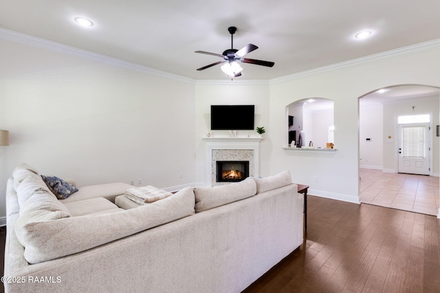 311 Victoria Lights Ln, Broussard, LA 70518 - living room with a ceiling fan, crown molding, dark wood-style flooring, a lit fireplace, and baseboards