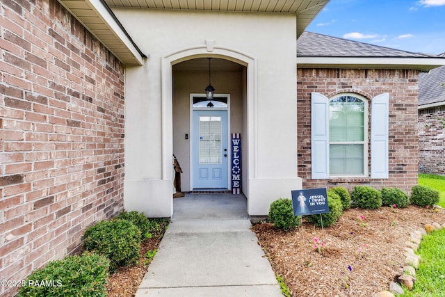 311 Victoria Lights Ln, Broussard, LA 70518 - property entrance featuring brick siding, a shingled roof, and stucco siding