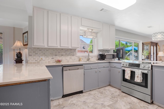 113 Templeton Dr, Lafayette, LA 70508 - kitchen featuring stainless steel appliances, a sink, a peninsula, backsplash, and gray cabinets