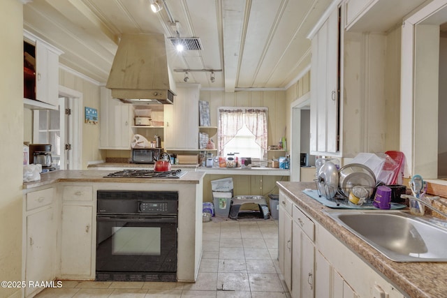 408 Section Ave, Rayne, LA 70578 - kitchen featuring oven, custom exhaust hood, light countertops, stainless steel gas cooktop, and a peninsula