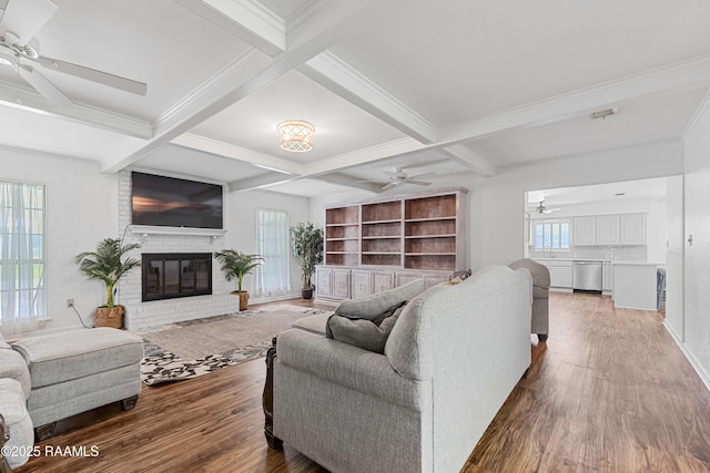 8001 Alpha Rd, Abbeville, LA 70510 - living area featuring a ceiling fan, beam ceiling, wood finished floors, coffered ceiling, and a brick fireplace
