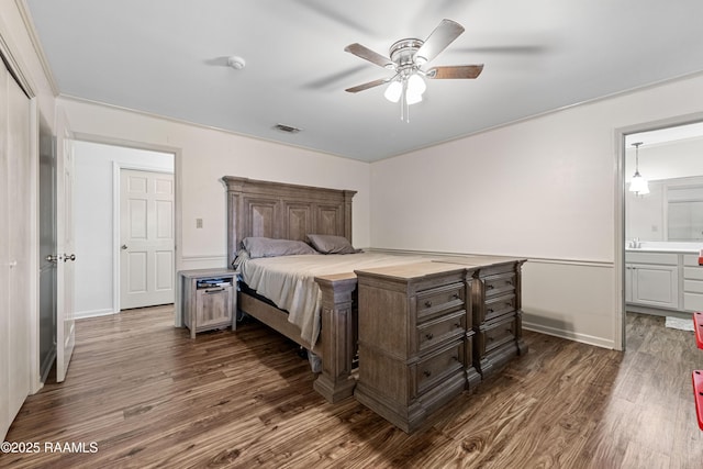 8001 Alpha Rd, Abbeville, LA 70510 - bedroom featuring dark wood finished floors, connected bathroom, a ceiling fan, and baseboards