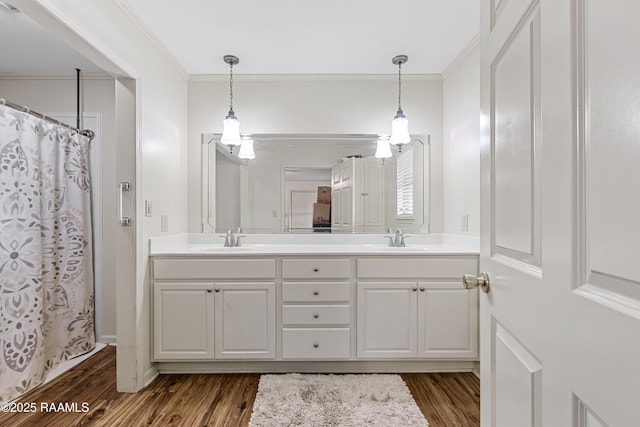 8001 Alpha Rd, Abbeville, LA 70510 - full bathroom featuring wood finished floors, double vanity, crown molding, and a shower with shower curtain