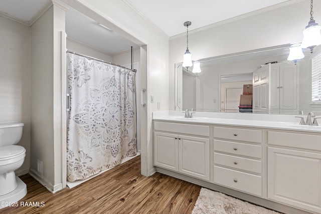 8001 Alpha Rd, Abbeville, LA 70510 - bathroom featuring toilet, wood finished floors, double vanity, crown molding, and curtained shower