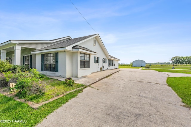 8001 Alpha Rd, Abbeville, LA 70510 - view of side of home featuring a shingled roof, brick siding, concrete driveway, and a yard