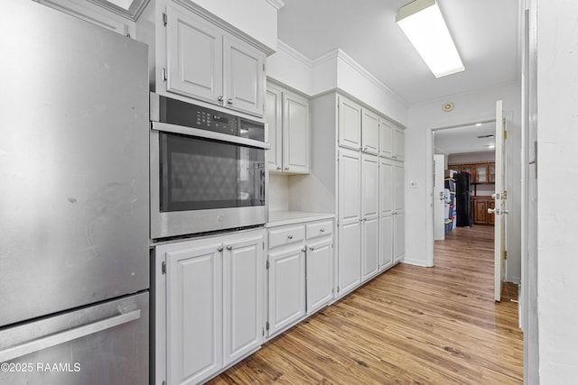 8001 Alpha Rd, Abbeville, LA 70510 - kitchen featuring stainless steel appliances, crown molding, light wood-style flooring, and light countertops