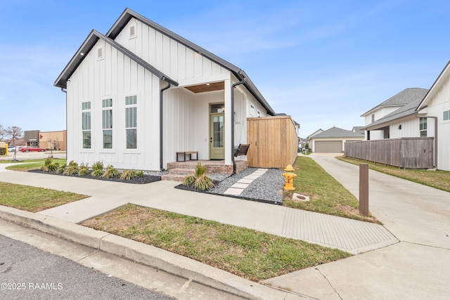 201 Lake Crest Ln, Youngsville, LA 70592 - modern inspired farmhouse featuring board and batten siding, a detached garage, and concrete driveway