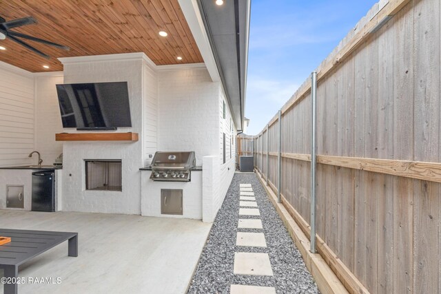 201 Lake Crest Ln, Youngsville, LA 70592 - fenced backyard featuring a ceiling fan, a patio, and a sink