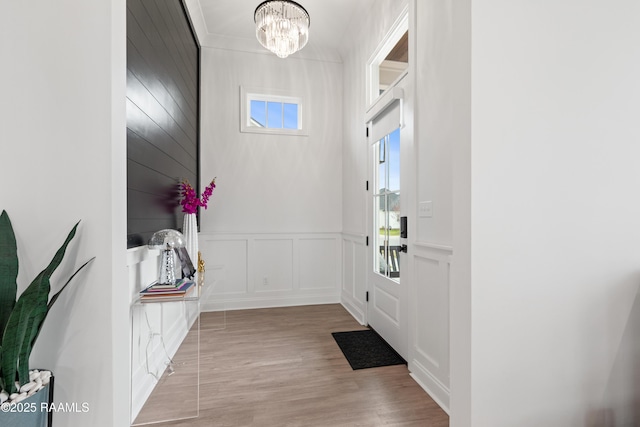 201 Lake Crest Ln, Youngsville, LA 70592 - foyer entrance with a decorative wall, a chandelier, wood finished floors, a wainscoted wall, and ornamental molding