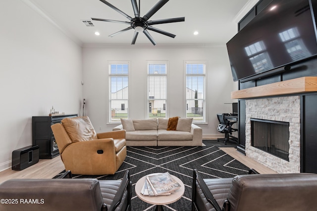 201 Lake Crest Ln, Youngsville, LA 70592 - living area with ceiling fan, crown molding, baseboards, wood finished floors, and a stone fireplace