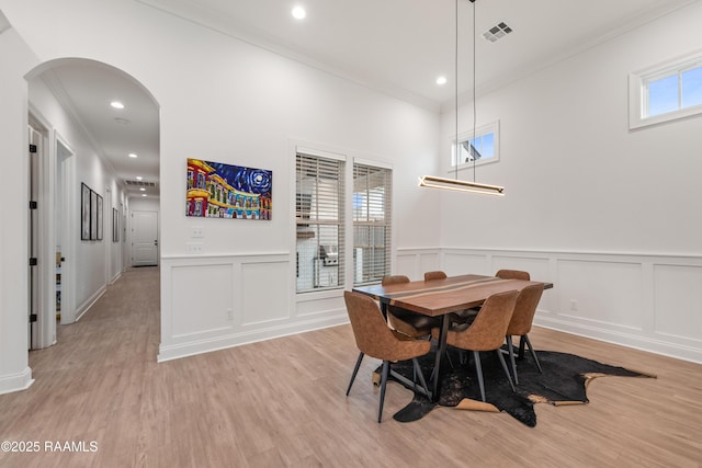 201 Lake Crest Ln, Youngsville, LA 70592 - dining room featuring ornamental molding, a decorative wall, arched walkways, light wood-style flooring, and recessed lighting