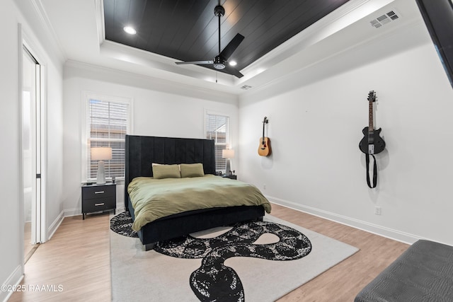 201 Lake Crest Ln, Youngsville, LA 70592 - bedroom featuring a raised ceiling, light wood-style floors, baseboards, crown molding, and ceiling fan