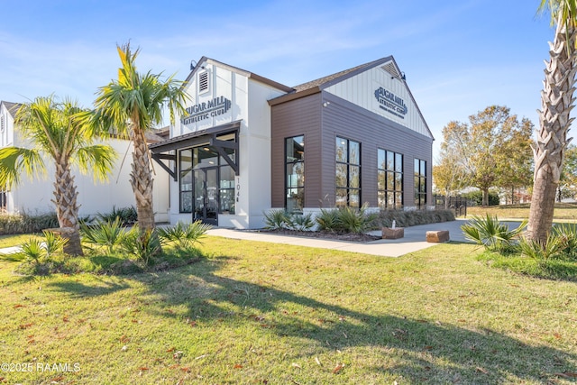 201 Lake Crest Ln, Youngsville, LA 70592 - rear view of house featuring a lawn and board and batten siding