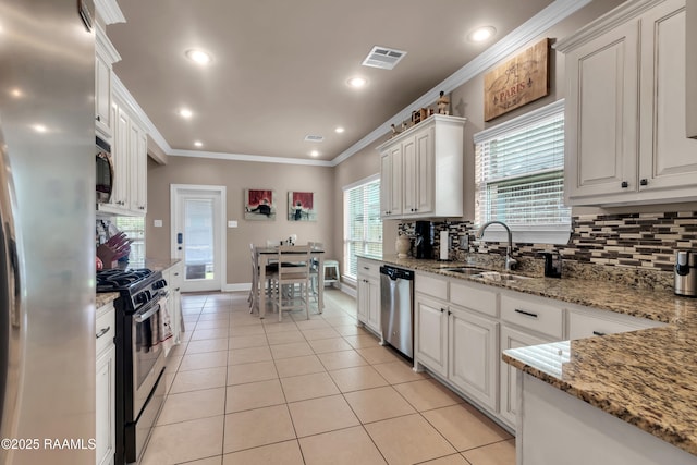 107 Ace Ln, Lafayette, LA 70506 - kitchen with appliances with stainless steel finishes, tasteful backsplash, ornamental molding, light tile patterned floors, and white cabinetry