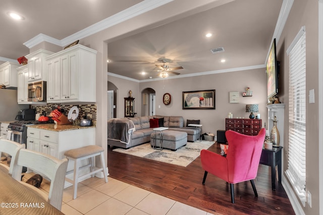 107 Ace Ln, Lafayette, LA 70506 - living room featuring arched walkways, a ceiling fan, light tile patterned floors, ornamental molding, and recessed lighting