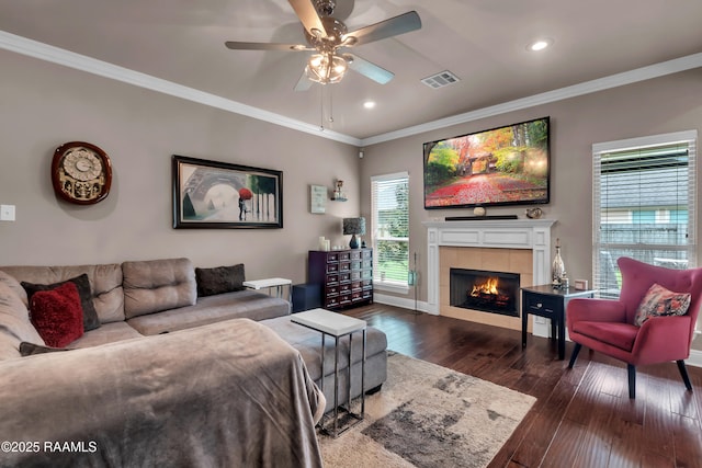 107 Ace Ln, Lafayette, LA 70506 - living room featuring dark wood-type flooring, a tiled fireplace, a ceiling fan, ornamental molding, and recessed lighting