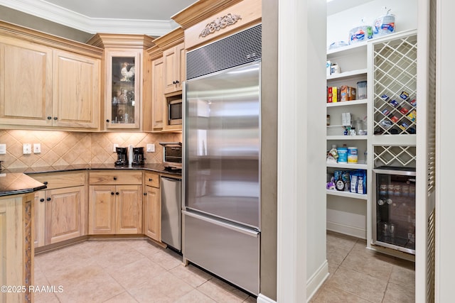 2822 Teal Dr, New Iberia, LA 70560 - kitchen with appliances with stainless steel finishes, light tile patterned floors, light brown cabinets, dark countertops, and crown molding