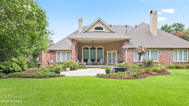 2822 Teal Dr, New Iberia, LA 70560 - back of house with a chimney, french doors, a lawn, brick siding, and a patio