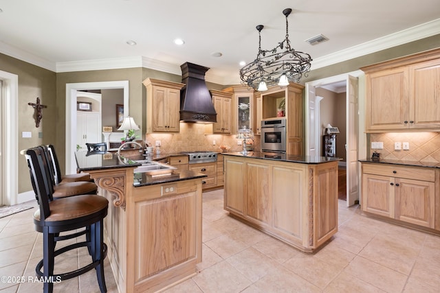 2822 Teal Dr, New Iberia, LA 70560 - kitchen featuring appliances with stainless steel finishes, custom range hood, light brown cabinets, a center island, and decorative backsplash